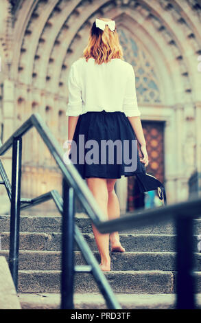 young female going back barefoot the stone stairs in historical center Stock Photo