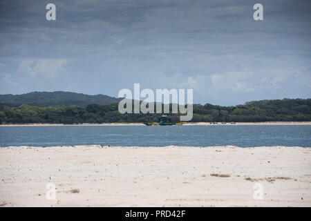 Beach on Fraser Island, Queensland Australia looking at the mainland in the summer with ferry crossing the sea Stock Photo