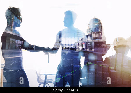 Silhouette of young workers shaking hands in the office. concept of teamwork and partnership. double exposure Stock Photo