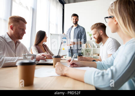 Achieving best results together. Modern young man conducting a business presentation while standing in the board room. Stock Photo