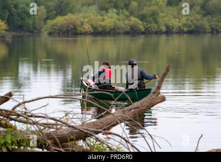 BOSSIER CITY, LA., U.S.A. - Sept. 29, 2018: A man and boy are seen from the rear in a canoe on a beautiful, quiet lake during a fishing trip. Stock Photo