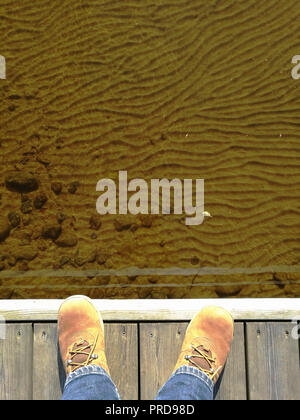 feet in suede shoes on a wooden dock Stock Photo