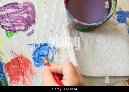 Top view of color palette and artist hand mixing paints with brush. Flat lay, Multicolored vibrant colorful art background. Stock Photo