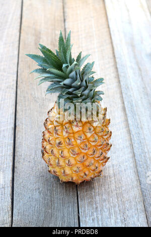 Close up of whole pineapple isolated on wooden background Stock Photo