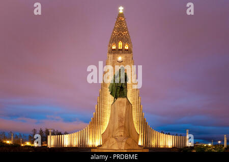 Illuminated Hallgrímskirkja with statue of Leif Eriksson at dusk, Reykjavik, Iceland Stock Photo