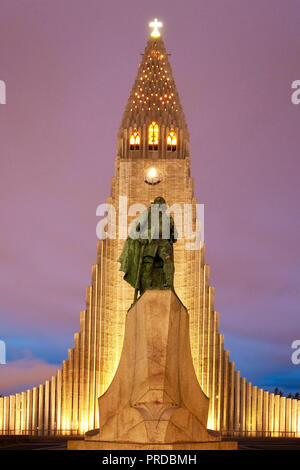 Illuminated Hallgrímskirkja with statue of Leif Eriksson at dusk, Reykjavik, Iceland Stock Photo