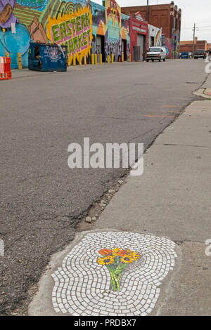 Detroit, Michigan - A pothole patched with an artistic mosaic of flowers on a street in the Eastern Market district. Chicago artist Jim Bachor patched Stock Photo