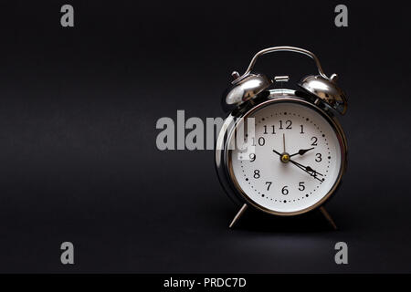 vintage alarm clock on black background.For time concept.