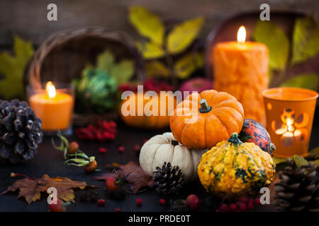 Autumnal colorful  pumpkins  on candle and fallen leaves background, Hallloween or Thanksgiving concept Stock Photo