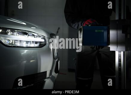 Headlight Aimer in Front of Modern Vehicle. Light Beam Test in the Professional Auto Service. Car Headlight Adjustment and Aim. Stock Photo