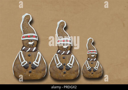 three gingerbread cookies, men, isolated on brown background, close up, flat lay Stock Photo