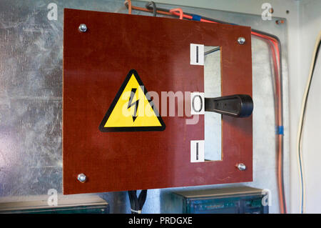 Old electrical switchboard on the wall. Industrial background. Stock Photo