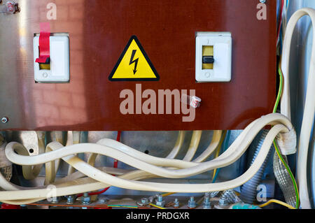 Old electrical switchboard on the wall. Industrial background. Stock Photo