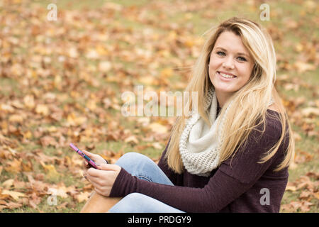 Happy young girl in a fall setting smiling. Stock Photo