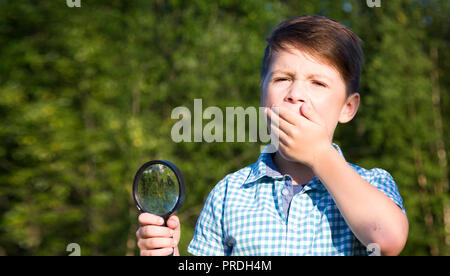 Shocked boy with magnifying glass Stock Photo