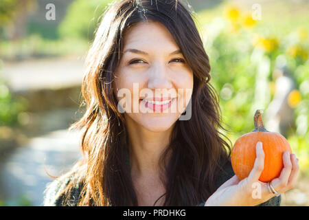 Young hispanic woman holding pumpkin seeds bowl smiling happy pointing ...