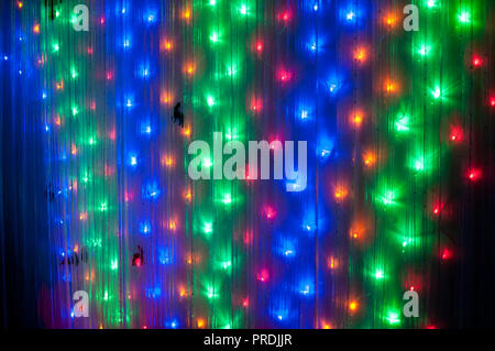 Small colorful  lights on wall as decoration for New Year party, lighting background Stock Photo