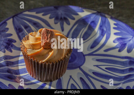 A chocolate cupcake on a blue patterned plate. Stock Photo