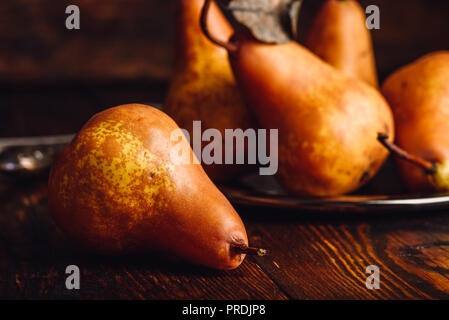 Few Golden Pears with Fork and Knife on Wooden Table. Stock Photo