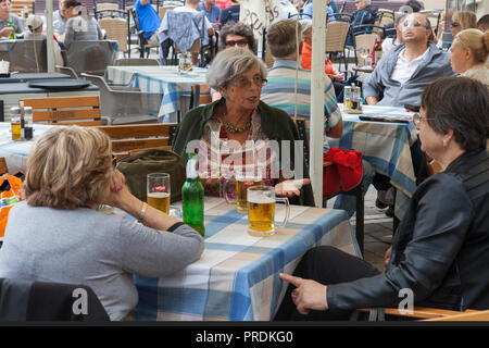 Women drinking beer at a café in the main square of the old town in Brasov, Romania Stock Photo
