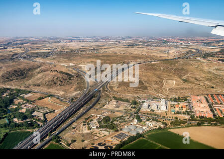 Airplane window view showing wing of a plane flying over Madrid, Spain, Arriving to international airport Stock Photo