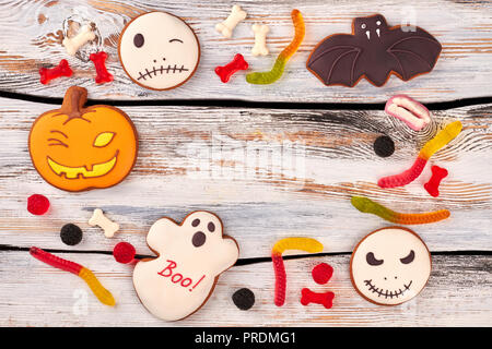 Halloween cookies and candies on wooden background. Stock Photo