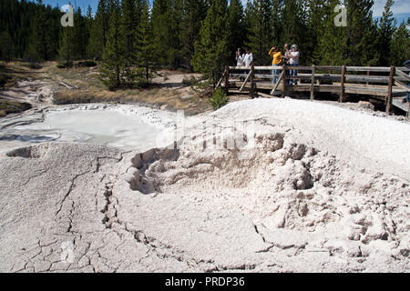 Tourists view the Artists Paintpots, a bubbling pool of hot mud, south of Norris Geyser Basin in Yellowstone Nat. Park, Wyoming. Stock Photo
