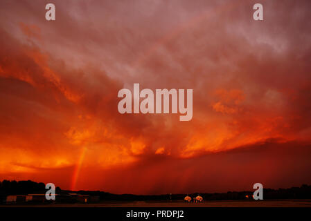 Rainbow over the Airport against the Backdrop of a Fiery Sunset in Front of a Storm. The State of Michigan, Grand Haven Stock Photo