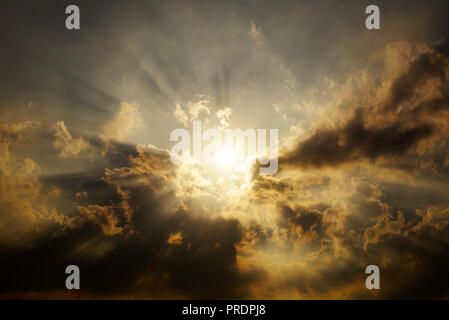 The Sunset Sky is Covered with Clouds. The Dark Thick Clouds and the Light Break Through them. Stock Photo