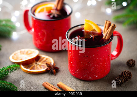 Two cups of christmas mulled wine or gluhwein with spices and orange slices on rustic table top view. Traditional drink on winter holiday Stock Photo