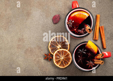 Two cups of christmas mulled wine or gluhwein with spices and orange slices on rustic table top view. Traditional drink on winter holiday. Top view with copy space Stock Photo