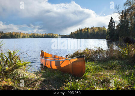 Canoe on the shore of a beautiful northern Minnesota lake during autumn Stock Photo