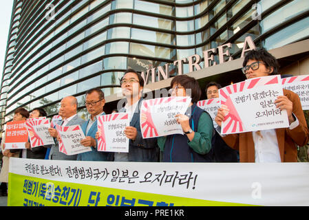 Protest against Japanese rising sun flag in South Korea, Oct 1, 2018 : South Korean activists from civic groups chant slogans at a press conference in front of the Japanese embassy in Seoul, South Korea. The protesters criticized Japan and its navy planning to display Japanese Rising Sun Flag, which protesters think as a symbol of wartime aggression, during the International Fleet Review to be held off the island of Jeju, South Korea from October 10-14. Navy ships from 15 countries including Japan, China and the U.S. will participate in the event. South Korean navy said on Sunday it remains in Stock Photo