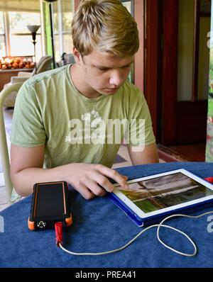 Recharging with solar powered Bigfoot Solar Power Bank from ToughTested, used to recharge iPad tablet or other mobile cell smart phones, from CES, USA Stock Photo