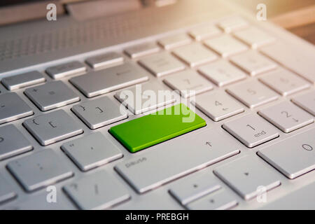 Keyboard with green blank Enter button modern pc text communication board. Color button on the gray silver keyboard of modern ultrabook. blank, Stock Photo
