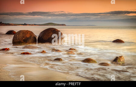 The famous Moeraki Boulders, an icon of New Zealand, in Otago, at sunrise. Stock Photo