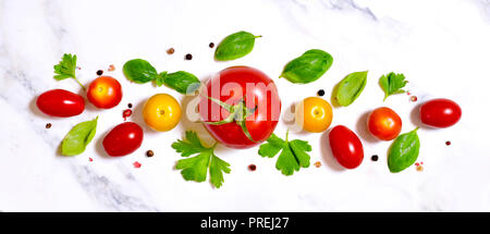 Delicious fresh tomatoes on a white marble stone background. Top view with copy space. Stock Photo