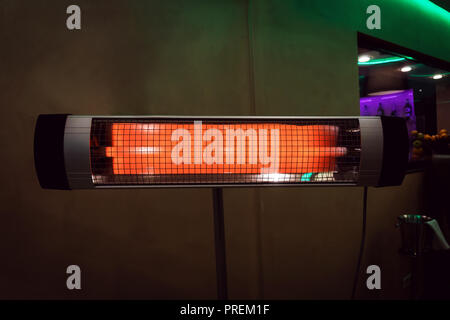 The electric heater in the room. heating the apartment in cold weather. Halogen or Infrared heater isolated on a white background Stock Photo
