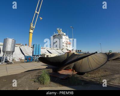 Cargo ship in dry dock for maintenance with large propeller in the foreground, port of Antwerp, Belgium Stock Photo