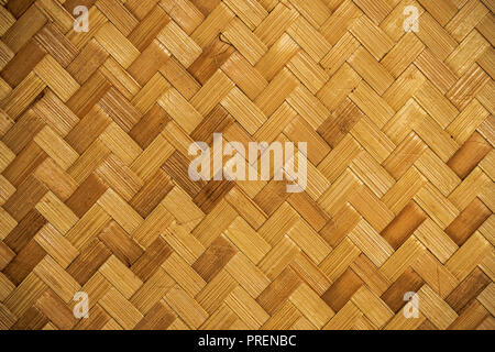 it is woven bamboo texture for background and design. yellow woven bamboo wall Stock Photo