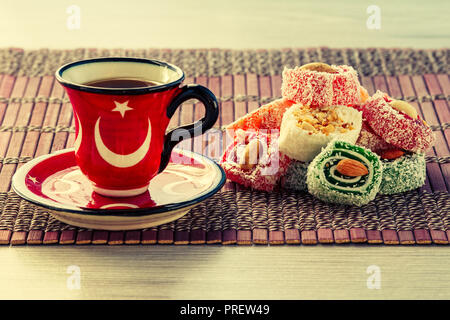 Cup of coffee on saucer and Turkish delight lying on bamboo cloth Stock Photo