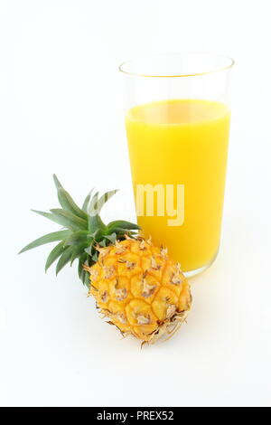 composition of a fresh pineapple and a glass of pineapple juice isolated on a white background with copy space Stock Photo