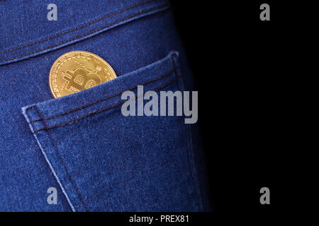 gold bitcoin in the back pocket of jeans, background image with space for text Stock Photo