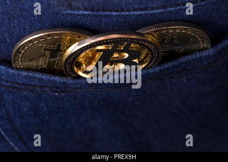 gold bitcoins in the back pocket of jeans, background image, photo from above