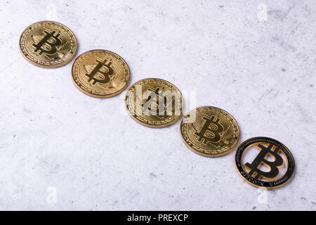 gold bitcoins on a concrete background, the concept of a falling crypto currency Stock Photo