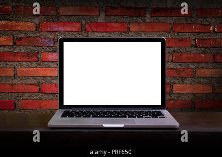 Mock up of blank laptop on the desk. Personal laptop computer on wood table over brick wall background. Stock Photo