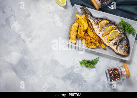 Grilled fish on stone plate with lemon Stock Photo
