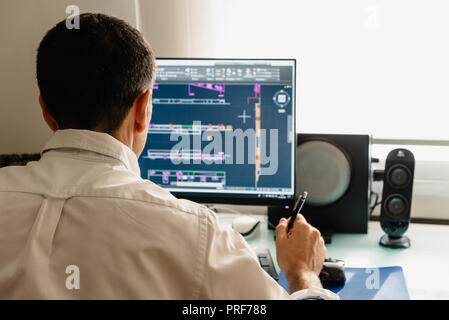 Architect drawing with cad software designing building. Rear view Stock Photo