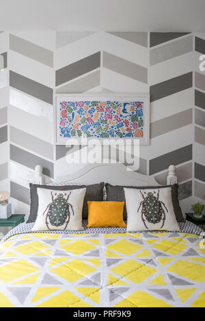 Assorted geometric patterns in bedroom with beetle cushions Stock Photo