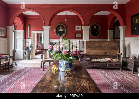 Wooden table and bench in red arched Georgian entrance interior Stock Photo